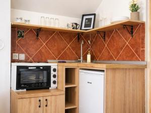 a kitchen with wooden cabinets and a white refrigerator at Airport Studio Loft - Galleria in Belgrade +17 photos