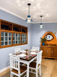 a dining room with a table and white chairs at Casa Julieta in Serra Negra