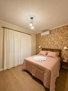 a bedroom with a bed with a pink bedspread at Casa Julieta in Serra Negra