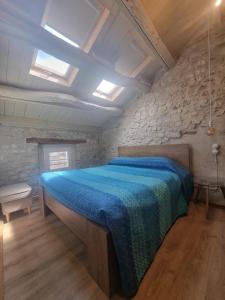 a bedroom with a large bed with a blue blanket at Olga's Paradise in Santa Croce del Lago