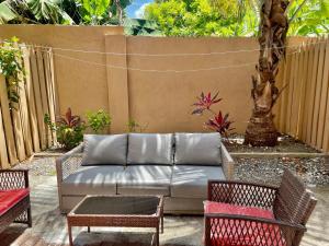 a patio with a couch and chairs and a fence at Palm Retreat in Ocho Rios