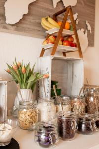 a table with jars of food and fruit on a shelf at Landhotel Strandallee in Wunstorf