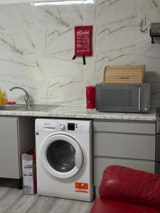a kitchen with a washing machine under a counter at Park View in Goodmayes