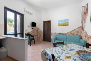 a living room with a blue couch and a table at Casa Sciura in San Vito lo Capo