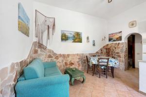 a living room with a blue couch and a stone wall at Casa Sciura in San Vito lo Capo