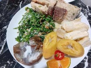 a plate of food with fruit and vegetables on a table at sandbar Homestay in Lautoka