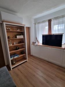 a living room with a tv and a window at Olga's Paradise in Santa Croce del Lago