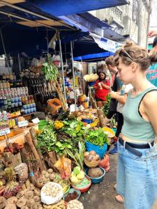 a woman standing in front of a market with vegetables at La Lagartija Iquitos in Iquitos