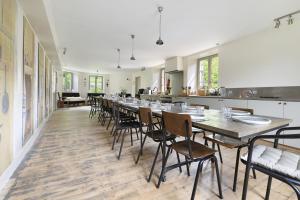 a long dining room with a long table and chairs at Chateau- La Providence in Satillieu