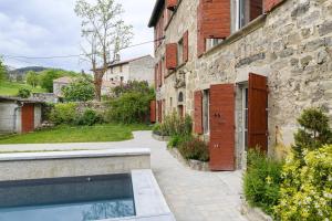 a house with a swimming pool next to a building at Chateau- La Providence in Satillieu