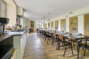 a long dining room with a long table and chairs at Chateau- La Providence in Satillieu