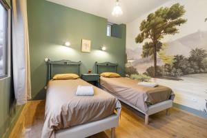 two beds in a room with a painting on the wall at Chateau- La Providence in Satillieu +36 photos