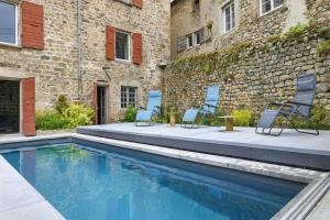 a swimming pool in front of a building with chairs at Chateau- La Providence in Satillieu