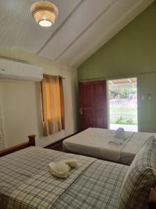 a bedroom with two beds and a large window at Rancho Primavera in Cuatro Esquinas