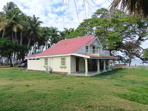 a small white house with a red roof at Rancho Primavera in Cuatro Esquinas