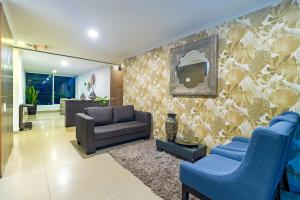 a living room with blue chairs and a couch at The Morgana Poblado Suites Hotel in Medellín
