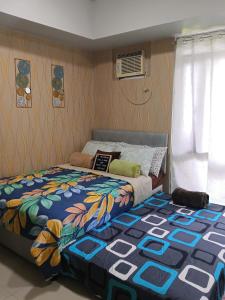 a bedroom with a bed with a colorful comforter at Manhattan Heights TowerD-Unit5 Viv's room Studio type in Manila +21 photos