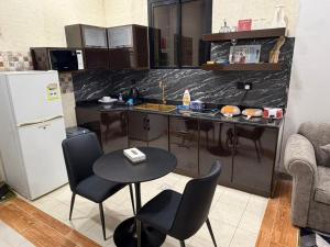 a kitchen with a table and chairs and a refrigerator at الجوهرة بارك للشقق المخدومة 7 in Riyadh