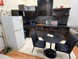 a kitchen with a refrigerator and a table and chairs at الجوهرة بارك للشقق المخدومة 7 in Riyadh +13 photos