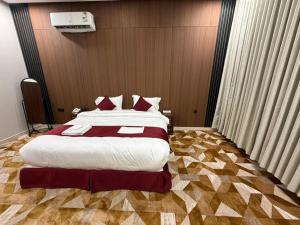 a bedroom with a large bed with red pillows at الجوهرة بارك للشقق المخدومة 7 in Riyadh