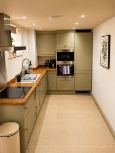 a kitchen with green cabinets and a counter top at Lilac Cottage in Barnard Castle