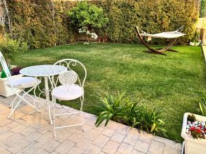 a patio with a table and chairs in a yard at Astrea Apartament in Tropea