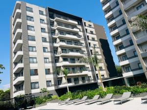 an apartment building with chairs in front of it at AccraAura-Airport Residential in Accra