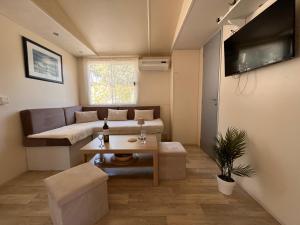 a living room with a couch and a table at Mobile Home Ana Mia in Biograd na Moru
