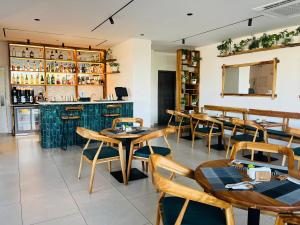 a restaurant with wooden tables and chairs and a bar at AccraAura-Airport Residential in Accra