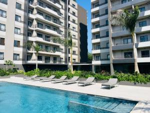 a swimming pool in front of a large apartment building at AccraAura-Airport Residential in Accra