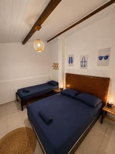 a bedroom with two blue beds and a chandelier at Nossa Casa Itacaré in Itacaré