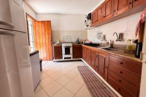 a kitchen with wooden cabinets and a white stove top oven at Nossa Casa Itacaré in Itacaré +38 photos