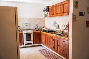 a kitchen with wooden cabinets and a white stove top oven at Nossa Casa Itacaré in Itacaré