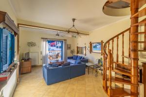 a living room with a blue couch and a television at VERANDA MARE in Agia Effimia