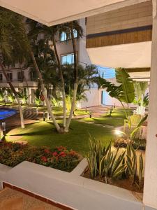 a view of a park with palm trees and a building at Apartamento vacacional en el Hotel Dynasty , Habitación tipo Estudio PRIVADO in Porlamar