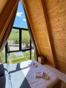 a bedroom with a bed and a large window at Monark Villas in Theth