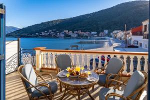 a balcony with a table and chairs and a view of the water at VERANDA MARE in Agia Effimia
