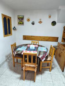 a dining room table with two chairs and a table with a quilt at Casa El Capulí in Cajamarca