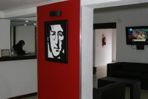 una pared roja con una foto de un hombre en ella en Palmas del Lago en Villa Carlos Paz