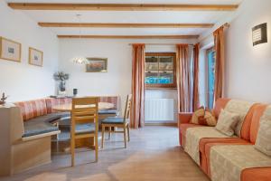 a living room with a couch and a table at Grafaierhof in Kastelruth