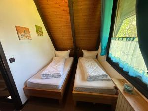 two beds in a small room with a window at Ferienhaus Im Abendrot in Waldbrunn