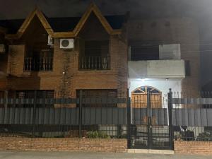 a house with a gate and a fence at Hostel amplio y confortable in Munro