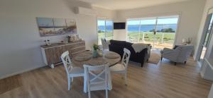a dining room and living room with a table and chairs at Pelican Lagoon Retreat in Pelican Lagoon