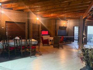a dining room with a table and chairs and a television at Hostel amplio y confortable in Munro