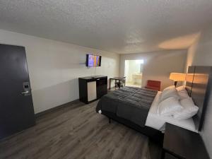 a hotel room with a bed and a flat screen tv at Skylite Inn in Austin +4 photos