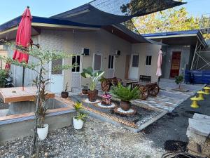 a house with a patio with potted plants and an umbrella at Amad's Rental Space Family Room in Bantayan Island