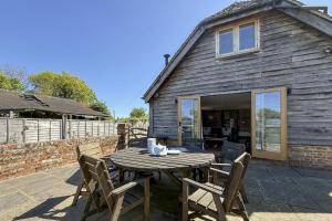 a wooden table and chairs in front of a house at 3 Bed in Tenterden oc-p36303 in Tenterden