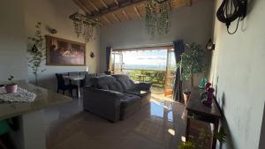 a living room with a couch and a table at Pousada Recanto Namastê - Mandalah in Cunha