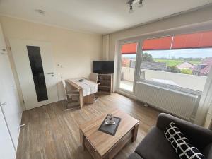 a living room with a couch and a table at Tief 12 Seeigel 31 in Wangerland