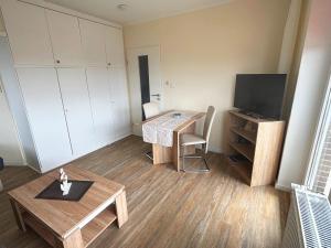 a small living room with a table and a television at Tief 12 Seeigel 31 in Wangerland +18 photos